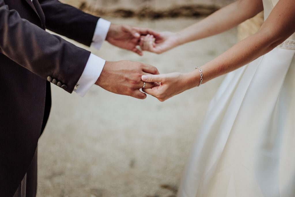 "A couple holding hands on the beach as they exchange wedding vows, symbolizing that marriage is a covenant of love and commitment."